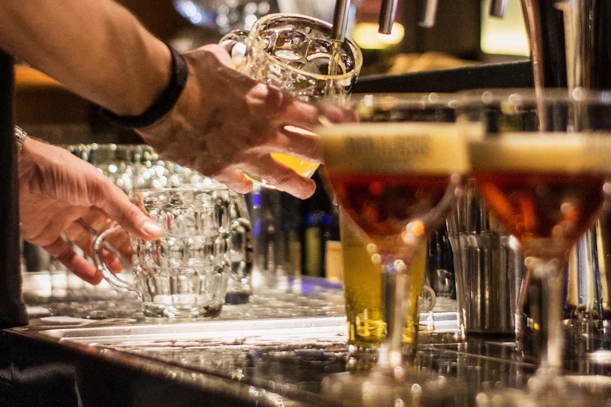 Bartender pouring beers at a warmly lit bar